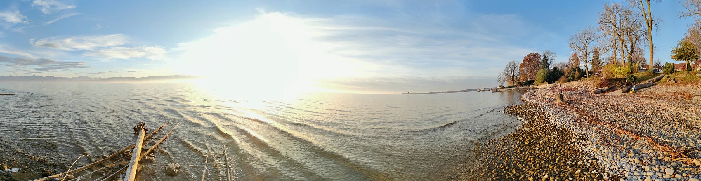 Kiesstrand am Bodensee mit Blick auf die Alpenkette